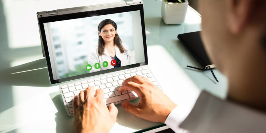 A man on his laptop having a video visit with his doctor.