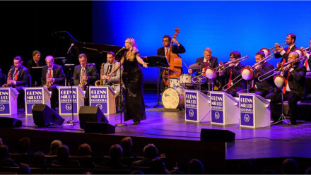 The World Famous Glenn Miller Orchestra during a performance at night.